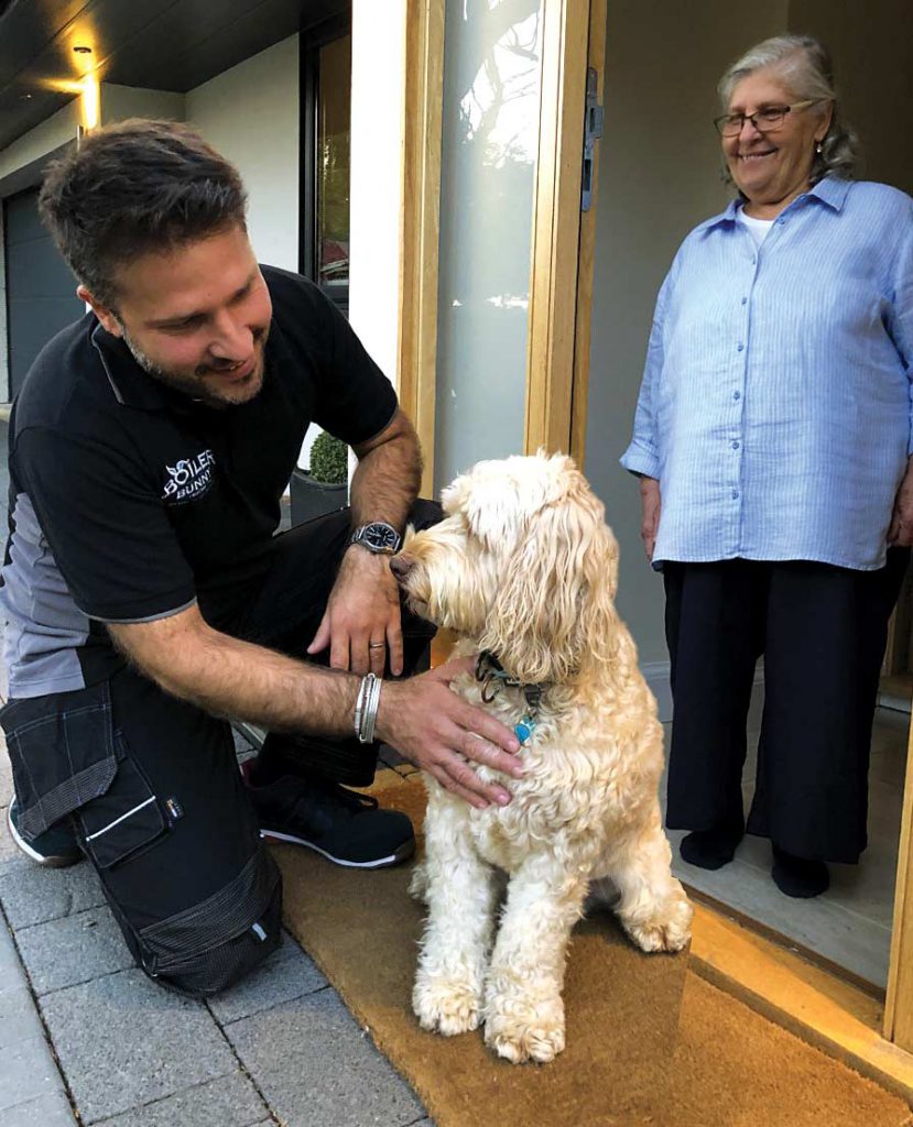 An expert Gas Safe Registered engineer with a customer’s dog after a professional boiler service in London, Lewisham, Sydenham - SE26.